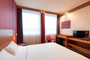 a hotel room with a bed and a television at Star G Hotel München Schwabing in Munich