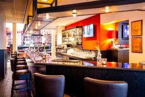 a bar in a restaurant with brown chairs at Bastion Hotel Maastricht Centrum in Maastricht