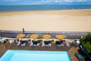 アルカションにあるArc Hôtel Sur Merのプールとビーチの景色を望めます。