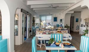 ein Zimmer mit Tischen und Stühlen mit Essen drauf in der Unterkunft Le Ancore Hotel in Vico Equense