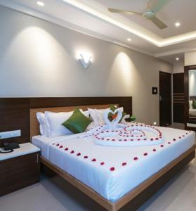 a bedroom with a bed with a cake on it at Hotel Kheni in Chennai