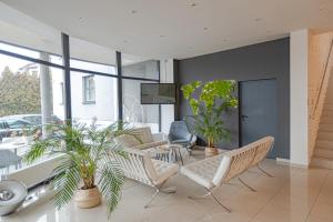 NoBo Hotel - business في لودز: غرفة معيشة مع كراسي وطاولة بالنباتات