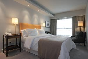 a hotel room with a bed and a chair and a window at Libertad Hotel Buenos Aires in Buenos Aires