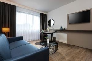 a living room filled with furniture and a tv at Holiday Inn Berlin City-West, an IHG Hotel in Berlin
