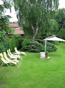 un grupo de sillas de césped y un paraguas en un patio en Haus Sonnenschein, en Lam