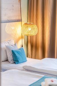 ウッチにあるNoBo Hotel - businessのベッド2台(ランプ、青い枕付)が備わる客室です。