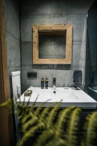 a bathroom with a white sink and a mirror at Apartment Alpinflair 1 in Kaprun +10 photos