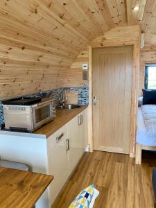 uma cozinha e sala de estar numa pequena casa em Fuaim na Mara - Self Catering Pod em Creagorry