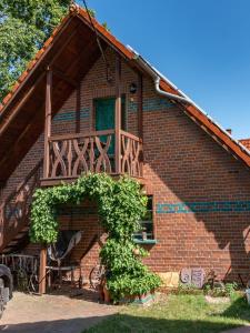 ein Backsteinhaus mit einer Holzveranda und einem Balkon in der Unterkunft Ferienwohnung Letsch in Burg