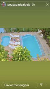a picture of a swimming pool with chaise lounges at Pousada da Aldeia in Serra