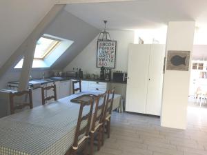 a kitchen with a table and chairs in a room at La Bossellerie in Courdemanche