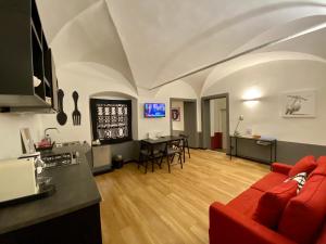 een woonkamer met een rode bank en een tafel bij New Apartament in historical Genoa center in Genua