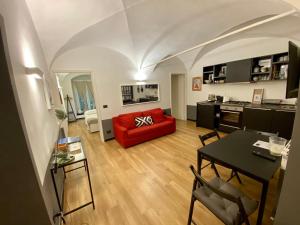een woonkamer met een rode bank en een tafel bij New Apartament in historical Genoa center in Genua