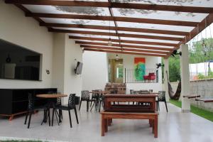 eine Terrasse mit Tischen und Stühlen und einem Flachbild-TV in der Unterkunft In Hospedagem in Paraty