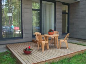 a wooden table and chairs on a porch with two plants at Palanga Apartaments - Mickevičiaus 8 in Palanga