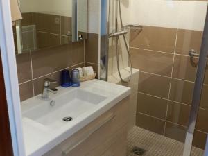 a bathroom with a sink and a shower at Grand Hotel Moriaz in Le Lavandou
