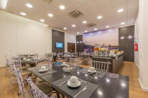 a restaurant with tables and chairs in a room at Bristol Guararapes Fortaleza Centro de Eventos in Fortaleza