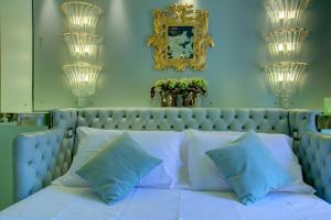 a bedroom with a blue bed with blue pillows at GranDELUX-Canal in Venice