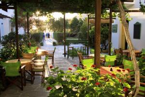 un patio con mesas, sillas y flores en Hotel Boulis en Kamarai