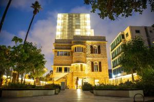 a building in front of a building at night at Schumacher Hotel Haifa in Haifa