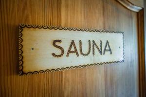 a sign that says sauna on a wooden wall at Osada na Brzyzku in Poronin