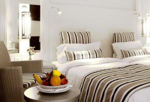 a bedroom with two beds and a bowl of fruit on a table at Djerba Plaza Thalasso & Spa in Midoun