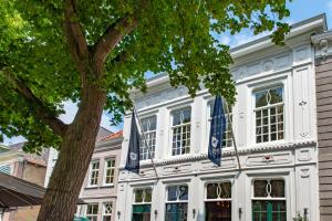 a white building with blue flags in front of it at Mondragon in Zierikzee