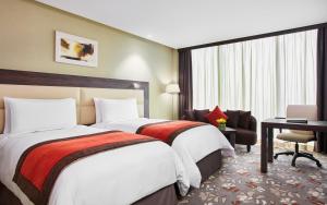 um quarto de hotel com duas camas e uma secretária em Crowne Plaza Kuwait Al Thuraya City, an IHG Hotel em Kuwait