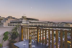 un balcone con un tavolo con bicchieri di vino sopra di Acropolis View - Living Stone Sapphire Apartment ad Atene