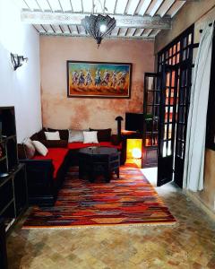 ein Wohnzimmer mit einem roten Sofa und einem Teppich in der Unterkunft RIAD DAR ASSALAMA Terrasse Vue Mer in Essaouira