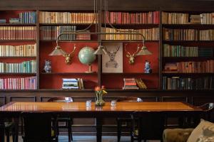 biblioteca con tavolo, sedie e libri di Restaurant & Hotel Hoog Holten a Holten