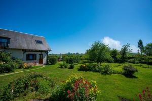 a house with a yard with flowers and plants at Gite des pâtissons in La Foret Du Parc