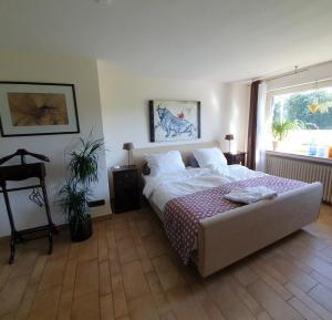 a bedroom with a large bed and a window at B&B Die Herrlichkeit in Lage