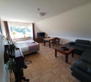 a living room with a couch and a bed and a table at B&B Die Herrlichkeit in Lage