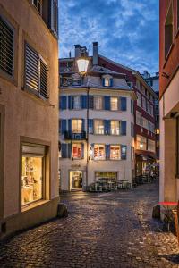 a cobblestone street in a city with a building at Marktgasse Hotel in Zurich