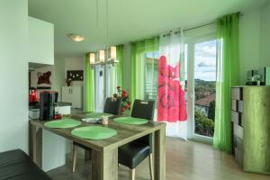 a kitchen with a wooden table with green curtains at Ferienwohnung Rose in Sipplingen