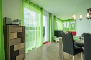 an office with green walls and a desk and chairs at Ferienwohnung Rose in Sipplingen