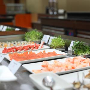 a buffet with several trays of food on a table at Crowne Plaza Kuwait Al Thuraya City, an IHG Hotel in Kuwait