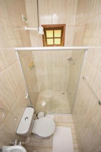 a small bathroom with a toilet and a shower at Pousada Luar do Sertão in Valença