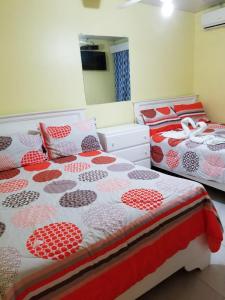 dos camas sentadas una al lado de la otra en un dormitorio en Hotel Victoriano, en San Felipe de Puerto Plata