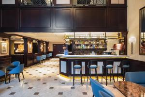a bar in a restaurant with blue chairs and tables at Radisson Blu Hotel, Gdańsk in Gdańsk