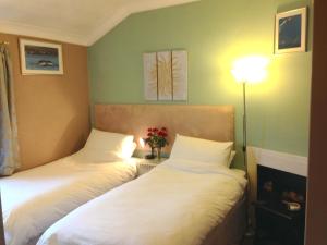 a bedroom with two beds and a lamp at The Old Station House in Matlock