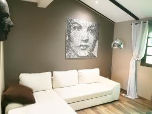 a living room with a white couch and a painting at Terra Rossa- clim- pieds dans l'eau in Conca