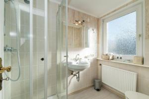 a bathroom with a sink and a shower at Strandläufernest in Tinnum