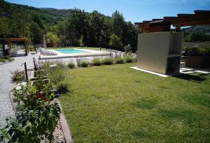 a garden with a swimming pool and a house at Villa San Francesco - Teloni in Assisi
