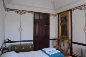 a bedroom with a bed and a wooden door at Casa do Sertório - Casa inteira in Évora