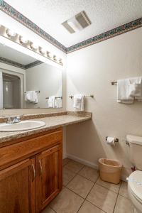 a bathroom with a sink and a mirror and a toilet at Crown Resorts at Lake Tansi West in Crossville
