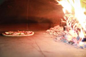 a pizza is being cooked in an oven at Hotel Restaurant du Parc en Bord de Rivière in Fontaine-de-Vaucluse