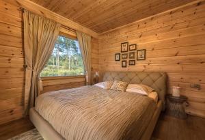 a bedroom with a bed in a log cabin at Rezidencia Woodchalet in Veľká Lomnica