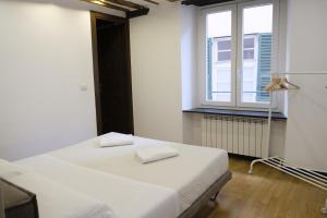 um quarto branco com uma cama e uma janela em H2omeMatteotti em Gênova